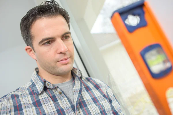 Erbauer mit Wasserwaage, um eine Wand zu überprüfen — Stockfoto