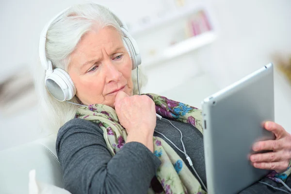 Senior senhora ouvindo música através de fones de ouvido — Fotografia de Stock