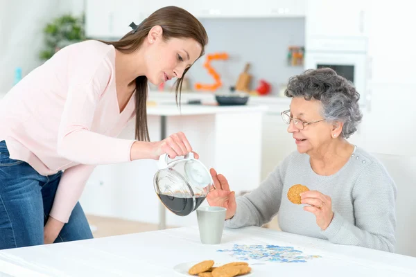 Pouring old lady a coffee — Stock Photo, Image