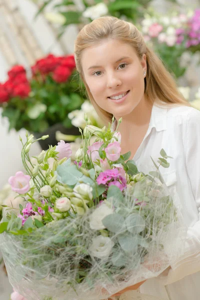 Florista segurando um arranjo de flores — Fotografia de Stock