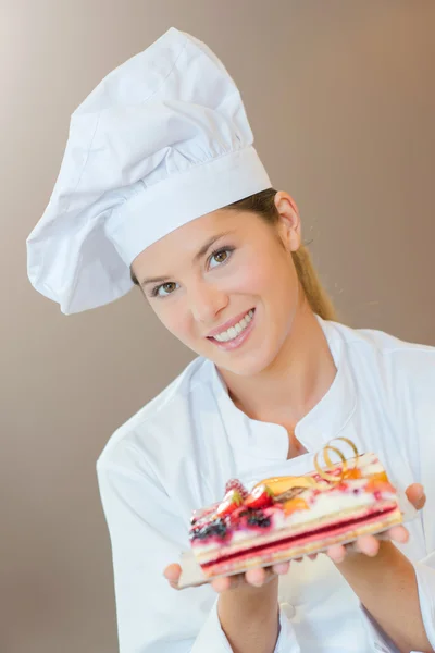 Femme chef de boulangerie avec un gâteau aux fruits — Photo