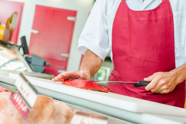 Butcher preparing a cut of beef in his shop — Stock Photo, Image