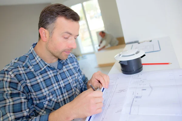 Builder going over construction plans — Stock Photo, Image