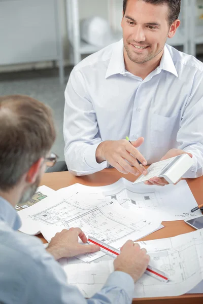 Architekten knackige Zahlen für einen Bauherrn — Stockfoto