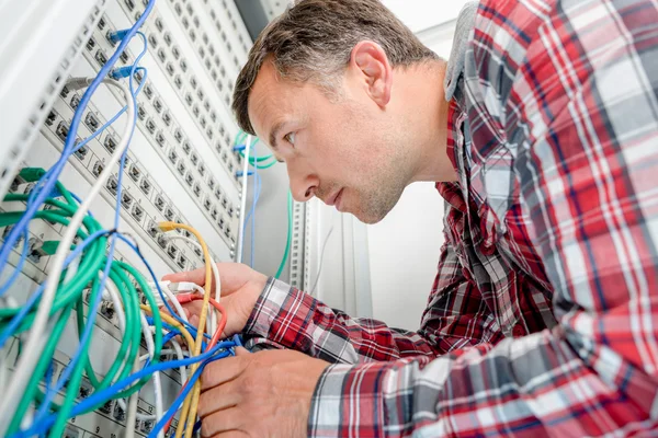 Computer technician checking wiring going to server — Stock Photo, Image
