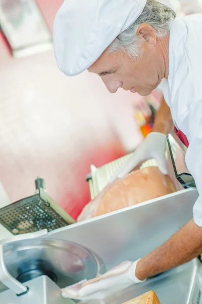 Hombre rebanando carne con la máquina — Foto de Stock