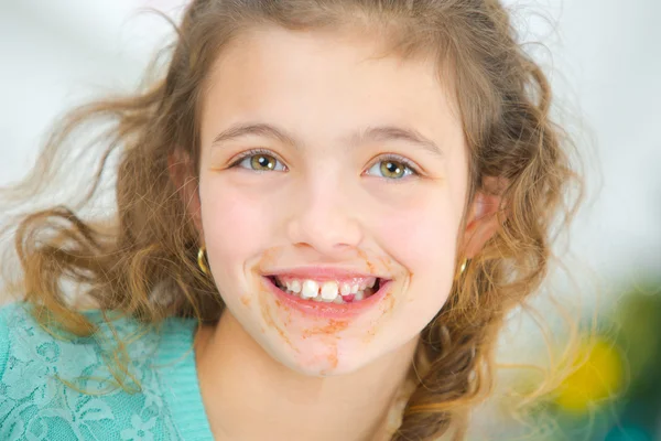Menina com chocolate em torno de sua boca — Fotografia de Stock