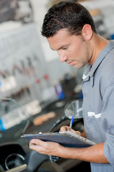Mechanic writing on his clipboard — Stock Photo, Image
