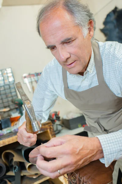 Schoenmaker hameren een paar schoenen — Stockfoto