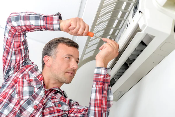 Man aan het werk op airconditioning unit, klep open — Stockfoto