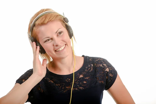 Jovem mulher ouvindo música através de fones de ouvido — Fotografia de Stock