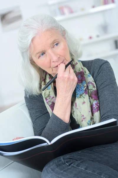 Stará dáma čtení na pohovce — Stock fotografie