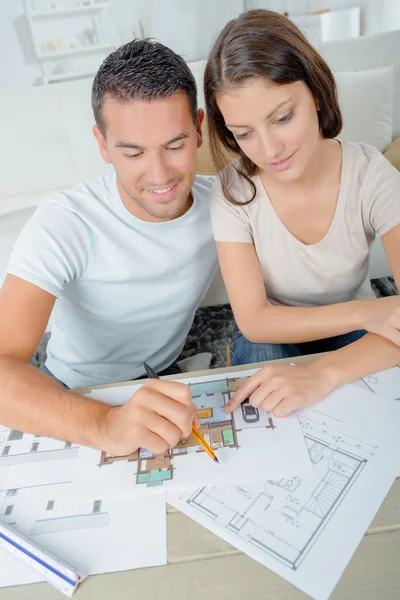 Couple regardant au-dessus des plans pour leur nouvelle maison — Photo