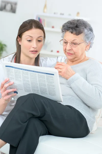 Lire un journal avec une vieille dame — Photo