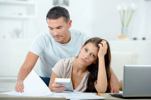 Paar mit Papieren, Taschenrechner und Computer — Stockfoto