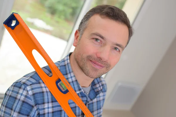 Handyman holding ett vattenpass — Stockfoto