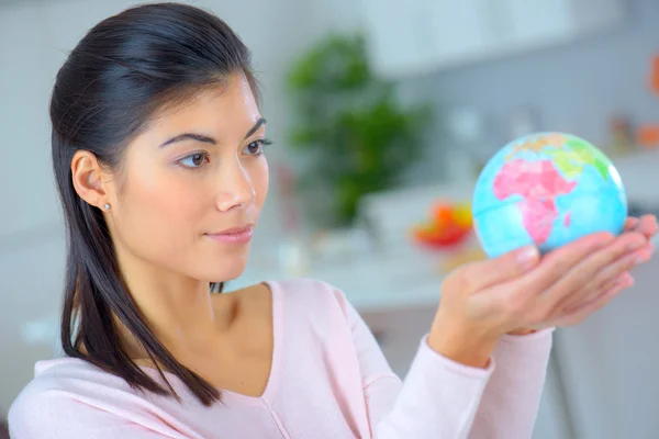 Vrouw met een miniatuur globe — Stockfoto