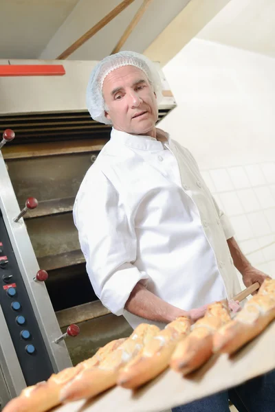 Panettiere rimuovere il pane dal forno — Foto Stock