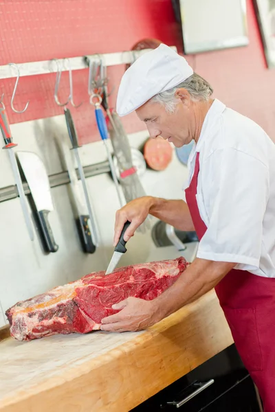 肉屋は肉を切る — ストック写真