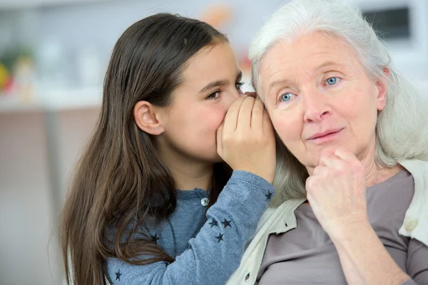 Liten flicka och mormor viskar hemligheter — Stockfoto