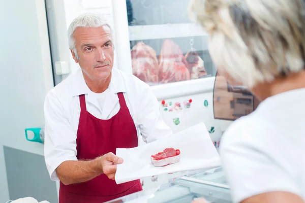 Metzger bereitet ein Stück Fleisch zu — Stockfoto