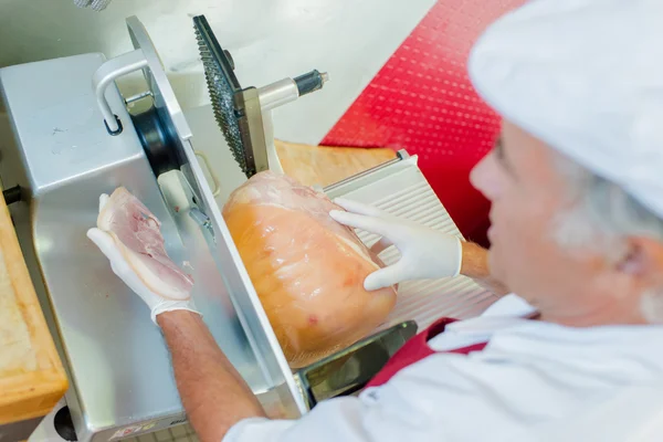 El hombre rebanando carne con la máquina, vista desde arriba — Foto de Stock