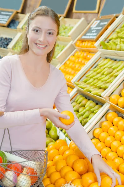 Mujer parada junto al puesto de frutas —  Fotos de Stock