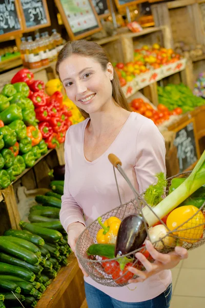 Дама тримає металевий кошик з фруктами та овочами — стокове фото