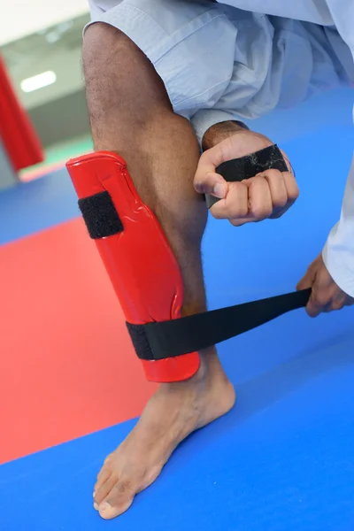 Artista marcial poniéndose un protector de piernas —  Fotos de Stock