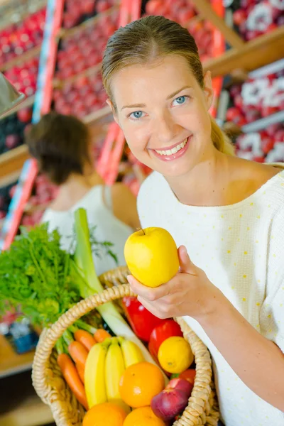 Mulher segurando uma cesta cheia de frutas diferentes — Fotografia de Stock