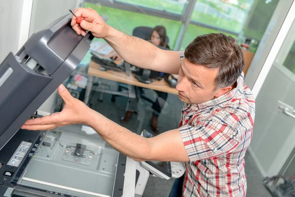 Hombre reparando fotocopiadora — Foto de Stock