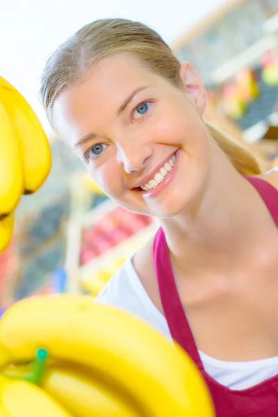 Pracownik supermarketu stał przez banany — Zdjęcie stockowe