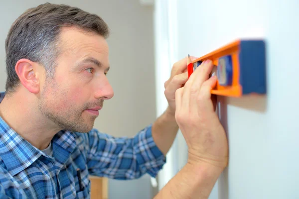 Builder med hjälp av ett vattenpass — Stockfoto