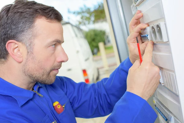 Electricista inspeccionando una caja de fusibles — Foto de Stock