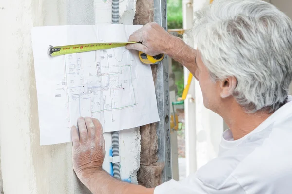 Bauunternehmer interpretiert Pläne — Stockfoto