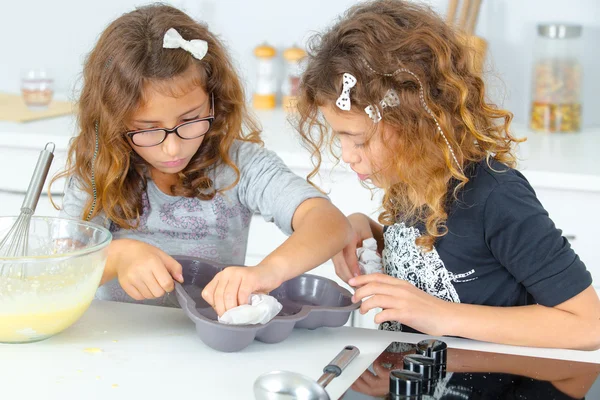 Kinderen schoonmaken taart schimmel — Stockfoto