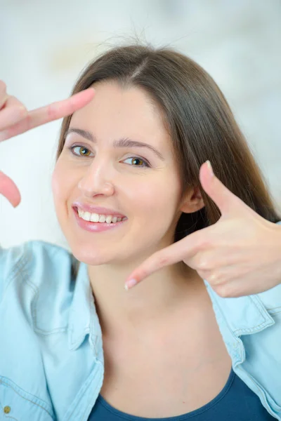 Mujer haciendo un marco alrededor de su cara con sus dedos —  Fotos de Stock