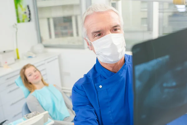 Dentista masculino olhando para um raio-x — Fotografia de Stock