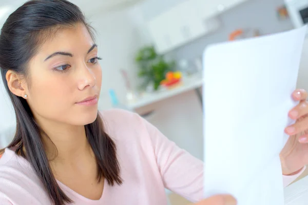 Frau liest zu Hause ein Dokument — Stockfoto