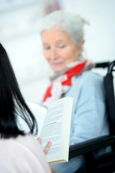 Att hjälpa äldre kvinna att läsa — Stockfoto