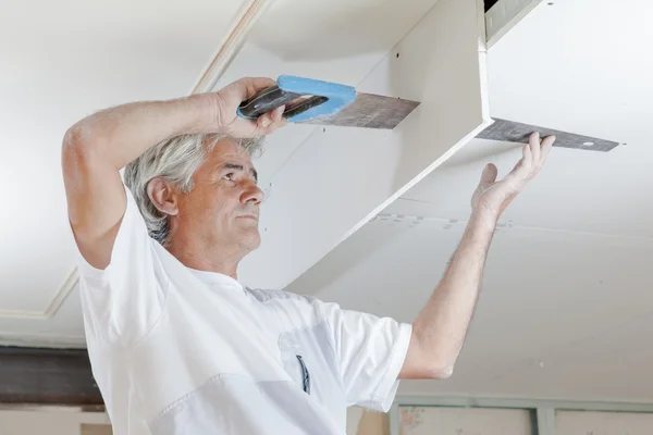 Sawing a ceiling panel — Stock Photo, Image