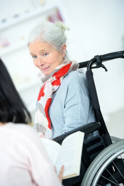 Helping senior woman to read — Stock Photo, Image