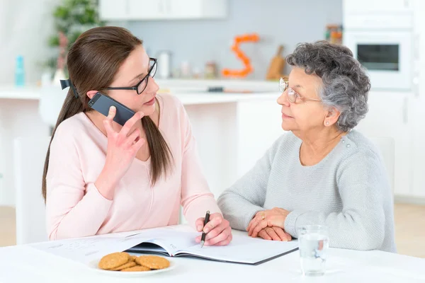 Att hjälpa gamla damen sortera sin ekonomi — Stockfoto