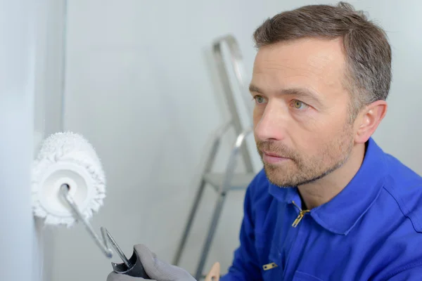 Homem pintando uma parede branca — Fotografia de Stock