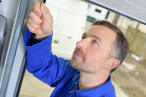 Homem instalando uma porta de garagem — Fotografia de Stock