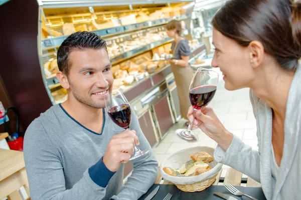 Casal beber vinho tinto com uma refeição — Fotografia de Stock
