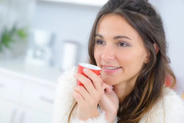 Kvinna som dricker kaffe i hennes kök — Stockfoto