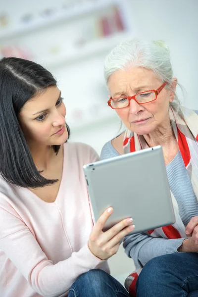 Att hjälpa gamla kvinnan använda tablet PC — Stockfoto