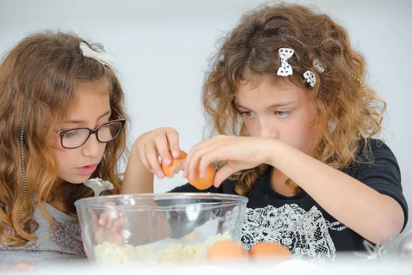 Chicas de la escuela rompiendo huevos en un tazón — Foto de Stock