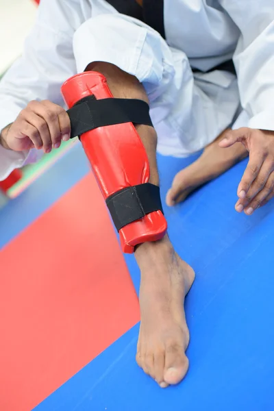 Fã de artes marciais colocando um guarda-pernas — Fotografia de Stock